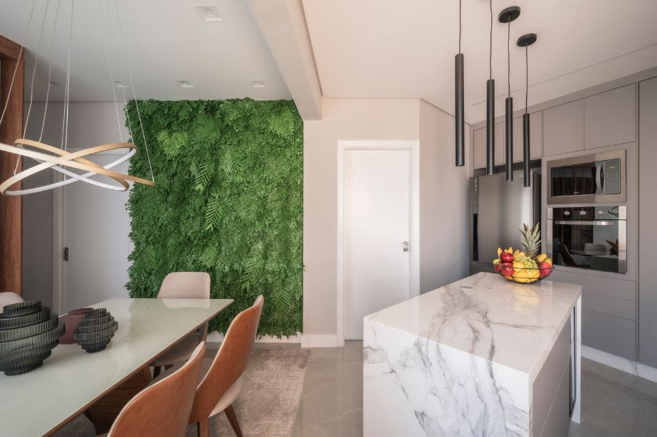 A parede verde de espécies preservadas trouxe um mix de vida, frescor e leveza para a sala de jantar integrada à cozinha | Projeto de PB Arquitetura | Foto: Photons Fotografia | Henrique Ribeiro